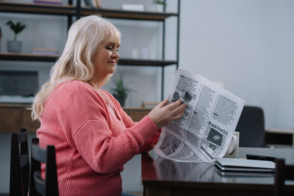 Babcia czyta artykuł na temat tego, kto nie może stosować chlorelli. 