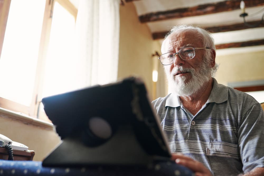 Dziadek czyta artykuł w internecie na temat cennych właściwości nasion chia.